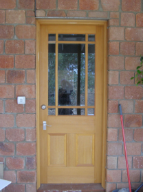Light timber paneled door with multi-pane glass insert