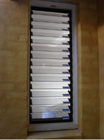 Modern louvre window in rendered terracotta wall